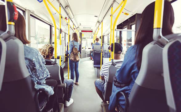 Sitzende und stehende Fahrgäste in einem städtischen Bus